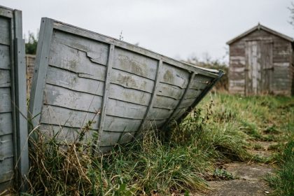 Clôture de jardin bon marché en plastique déformée et décolorée dans un jardin suburban, montrant les signes de dégradation rapide